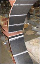Neoprene lining adhesively bonded to carbon steel riser clamps designed for FRP pipe.